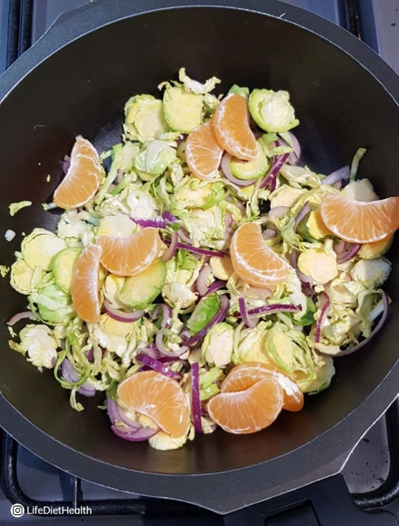 sprouts and satsumas in a pan